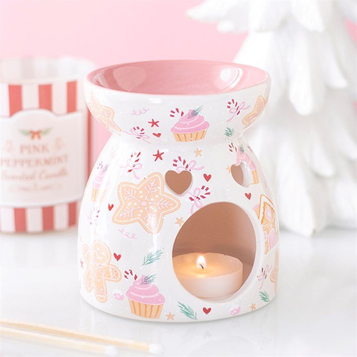 Quemador de wax melts con diseño de galletas de Navidad, vista frontal sobre fondo claro, decoración navideña artesanal
