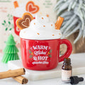 Quemador de wax melts con forma de taza de Navidad, vista frontal sobre fondo claro, decoración navideña artesanal y acogedora