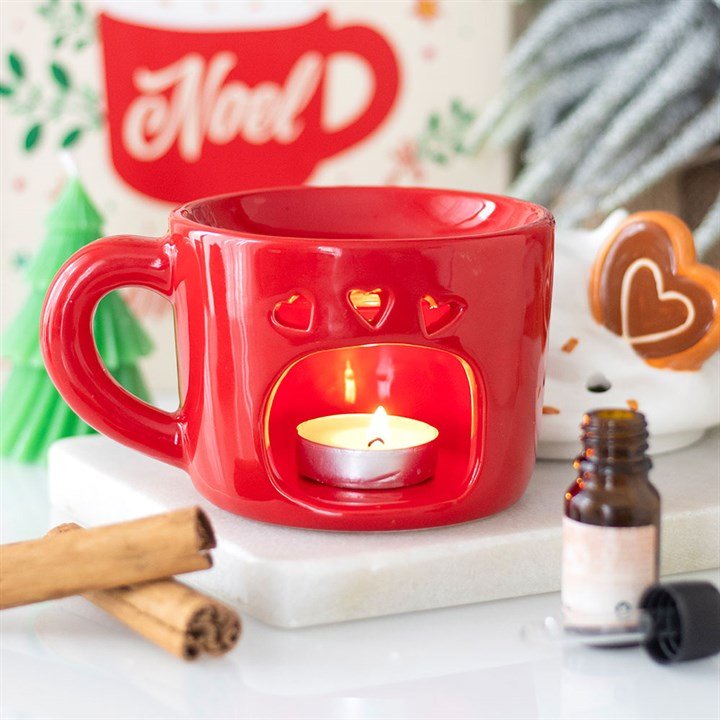 Detalle de quemador de wax melts navideño en forma de taza, acabado artesanal, ambiente cálido de hogar en Navidad