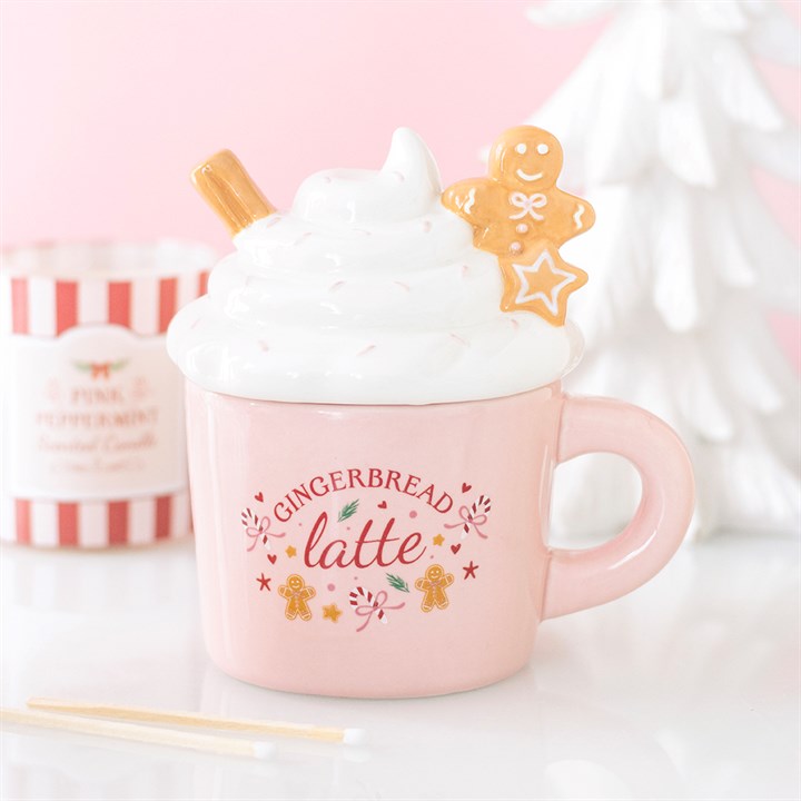 Quemador de wax melts con forma de taza de Navidad con motivo de jengibre, vista frontal sobre fondo claro, decoración navideña artesanal